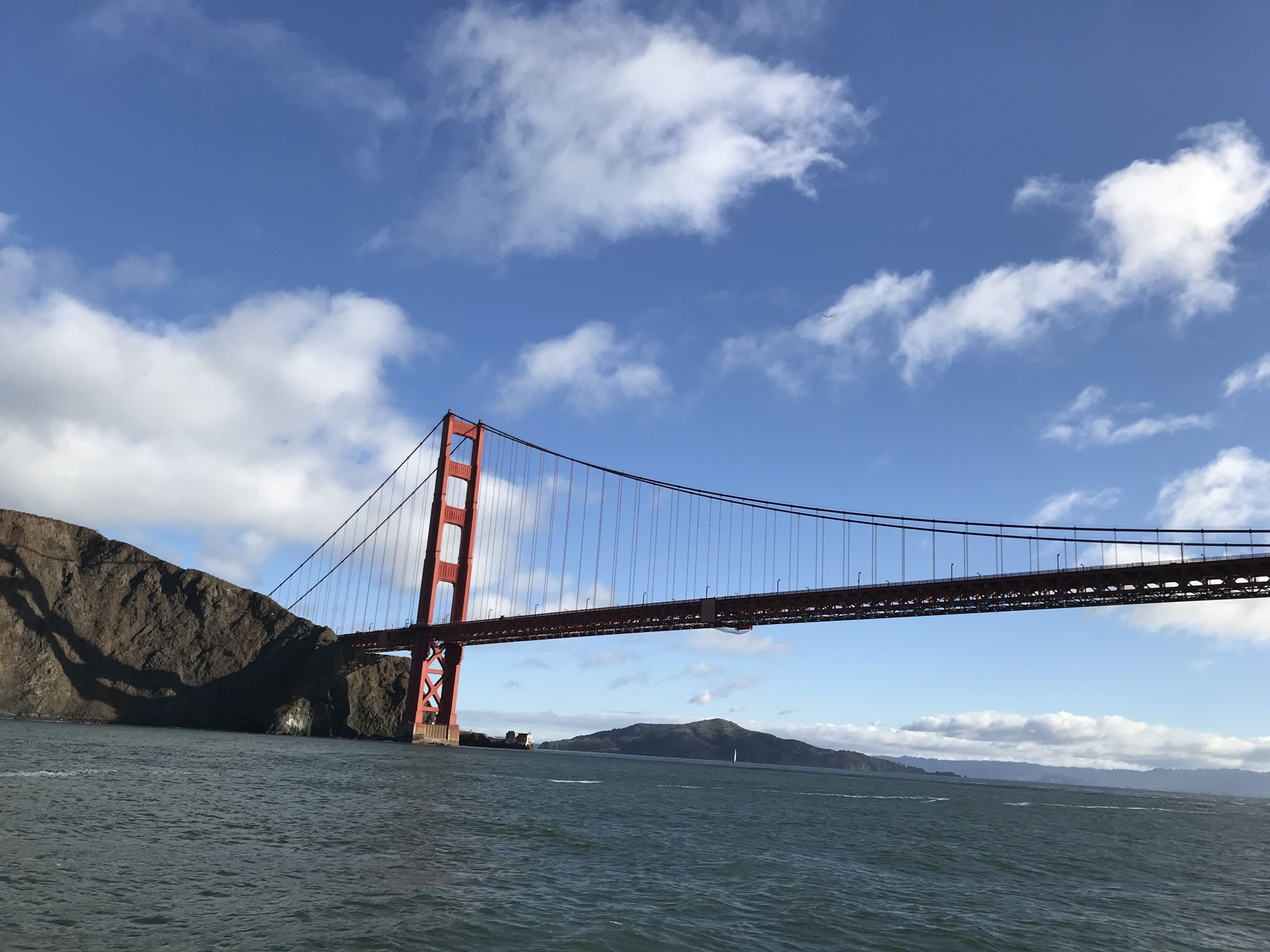 Scenic view of the Golden Gate Bridge from Marin County, California, overlooking San Francisco Bay with blue skies, coastal hills, and waterfront views. A symbol of the Marin County lifestyle, outdoor recreation, and convenient access to San Francisco.